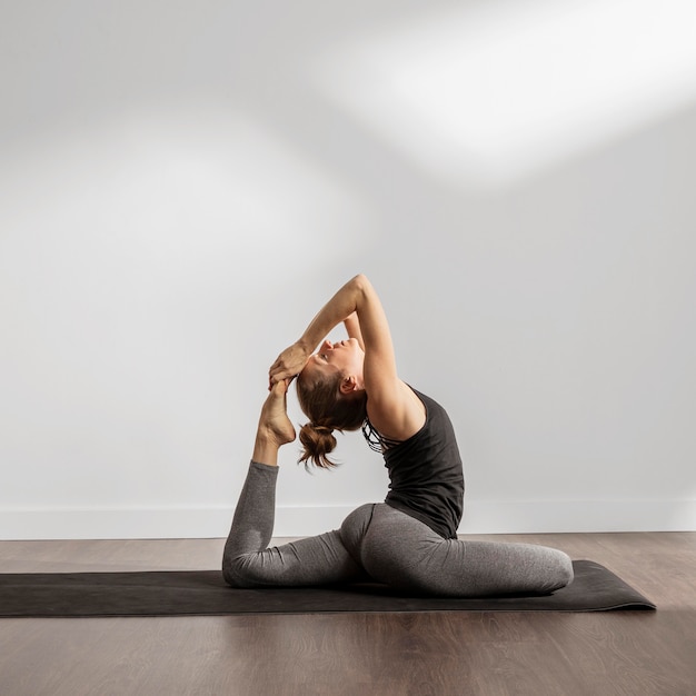 Foto gratuita mujer adulta haciendo yoga en casa