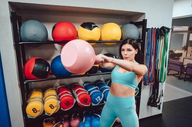 Mujer adulta joven haciendo ejercicios de fuerza en el gimnasio