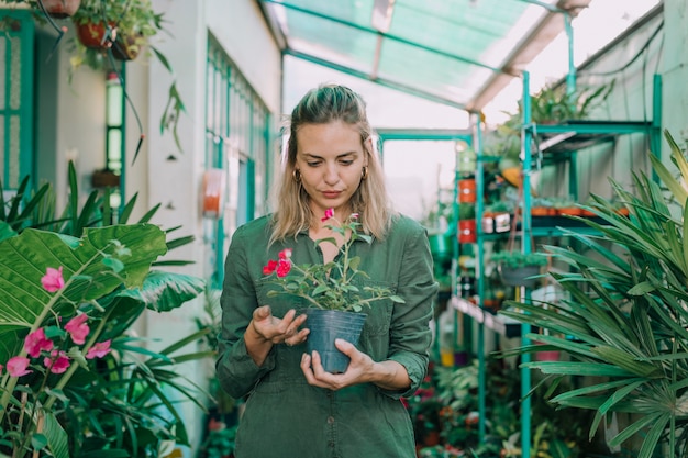 Una mujer adulta joven que trabaja en una tienda de jardinería