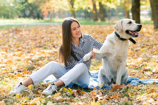 Mujer adulta jugando con su perro en el parque