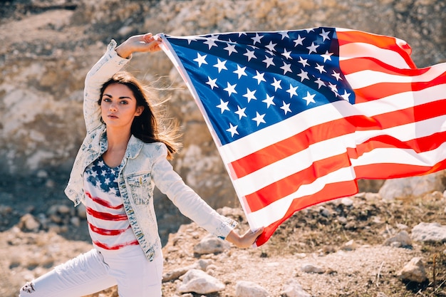 Mujer adulta levantando manos con bandera de USA
