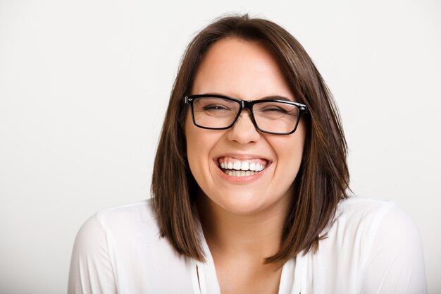 Mujer adulta linda tonta en gafas riendo