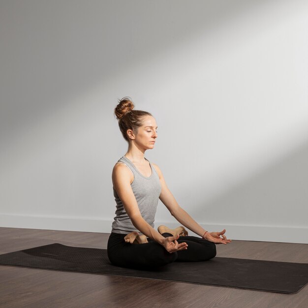 Mujer adulta meditando en casa