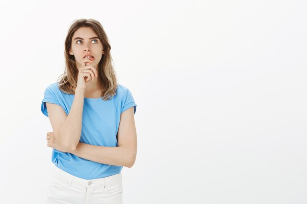 Mujer adulta pensativa mirando la esquina superior derecha, pensando, haciendo un plan