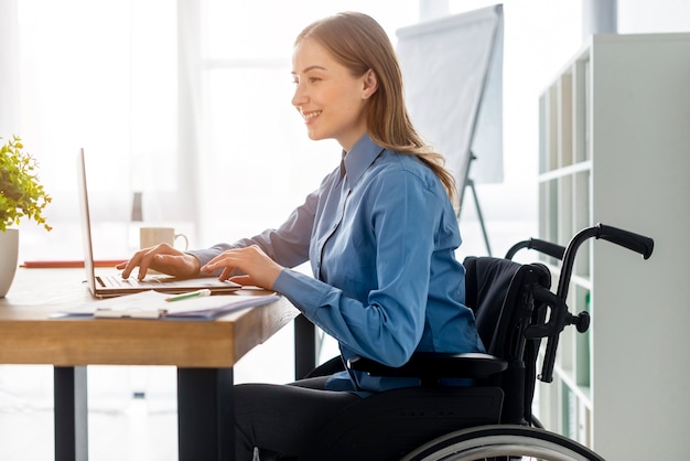 Mujer adulta positiva que trabaja en la oficina