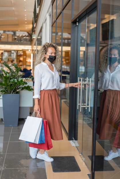 Mujer adulta, proceso de llevar, bolsas de compras