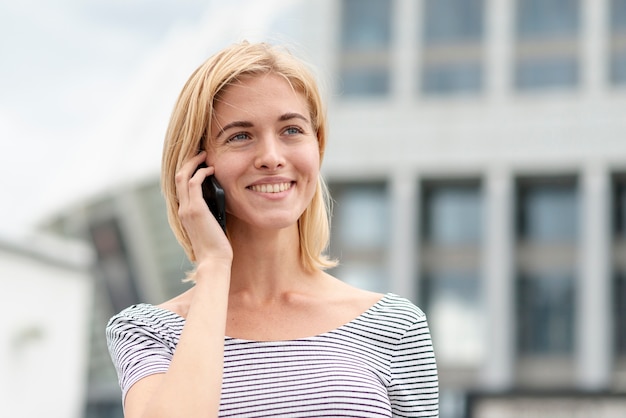 Mujer adulta sonriente hablando por teléfono