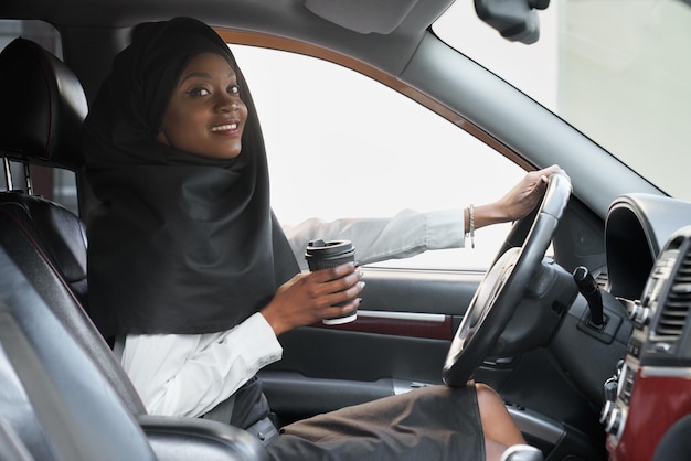 Mujer africana alegre posando sosteniendo una taza de café