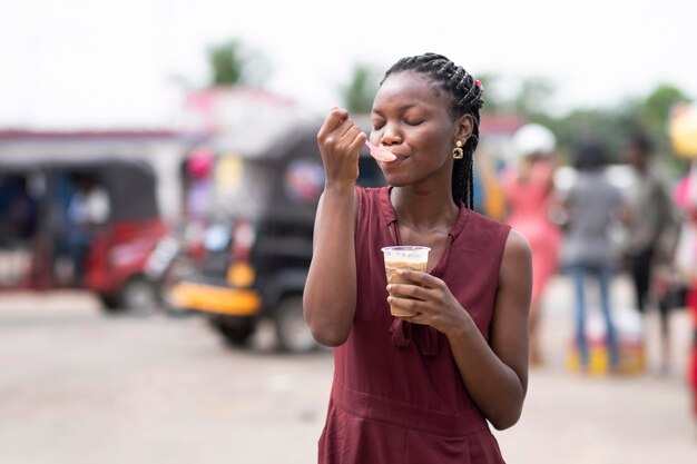 Mujer africana comiendo una bebida fría