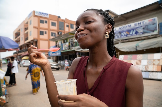 Mujer africana comiendo una bebida fría