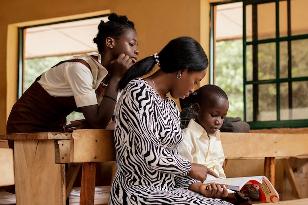 Foto gratuita mujer africana enseñando a los niños en clase