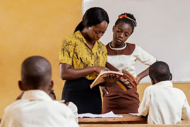 Mujer africana enseñando a los niños en clase