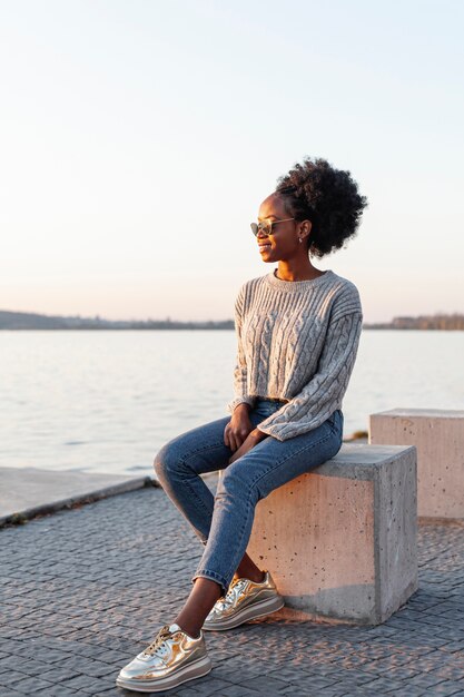 Mujer africana con gafas de sol y mirando a otro lado