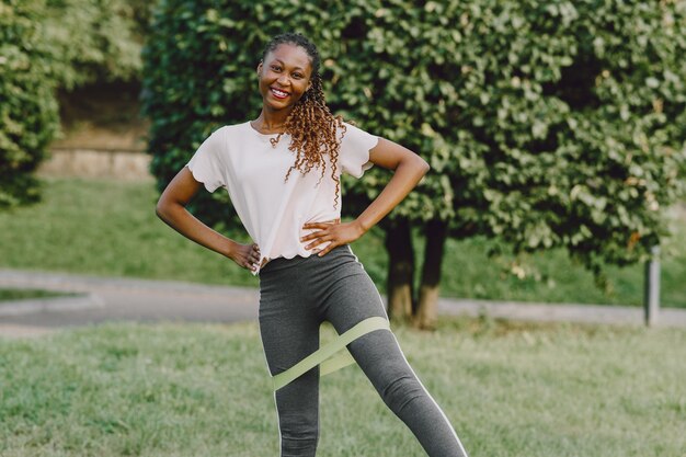 Mujer africana joven sana al aire libre en la mañana. Chica con goma de borrar.