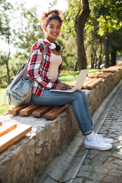 Mujer africana sentada al aire libre en el parque.