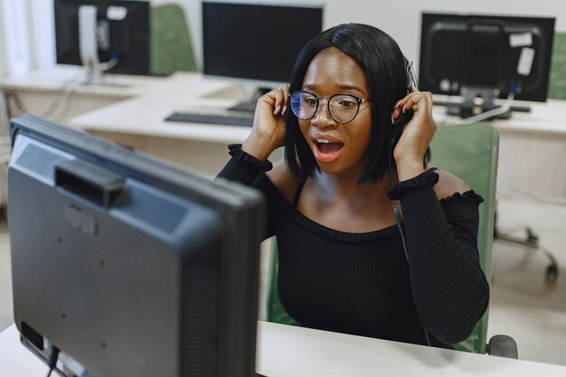 Mujer africana sentada en la clase de informática. Señora con gafas. Estudiante sentado en la computadora.