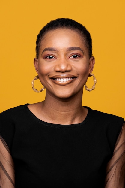 Mujer africana sonriente con aretes de oro