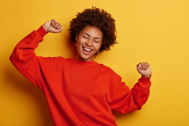 Mujer afroamericana baila alegremente riendo aislado