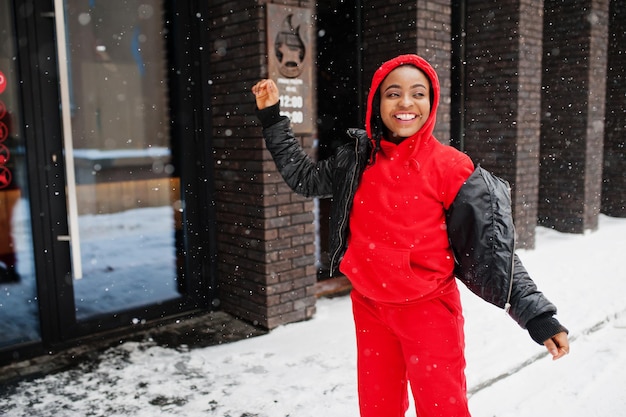 Mujer afroamericana con capucha roja disfruta del día de invierno