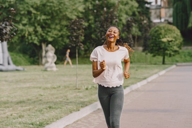 Mujer afroamericana con entrenamiento en el parque en ropa deportiva