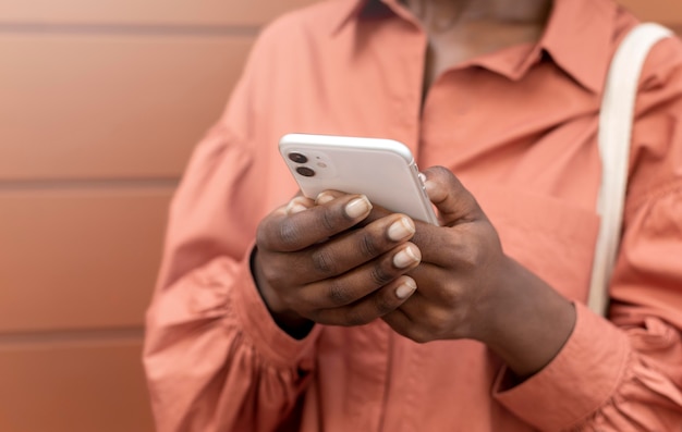 Mujer afroamericana enviar mensajes de texto a alguien en su teléfono inteligente