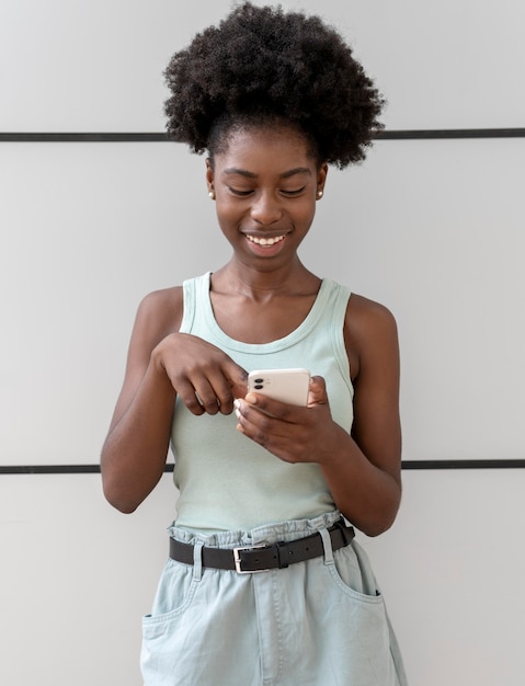 Foto gratuita mujer afroamericana enviar mensajes de texto a alguien en su teléfono inteligente