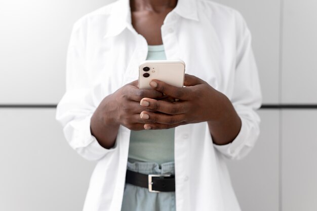 Mujer afroamericana enviar mensajes de texto a alguien en su teléfono inteligente