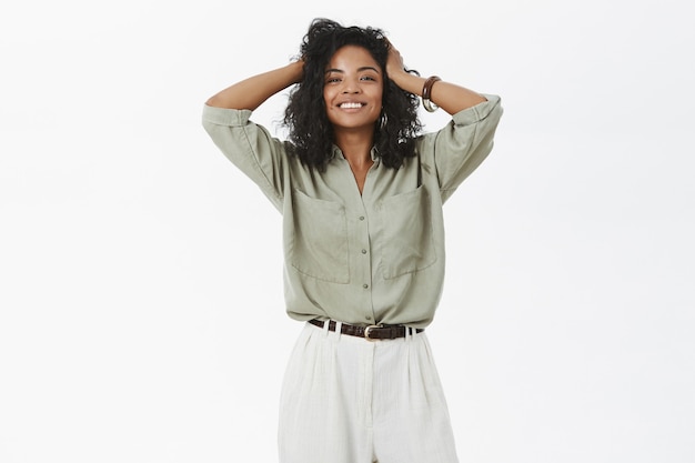 Mujer afroamericana feliz bastante enérgica y femenina satisfecha con el nuevo peinado