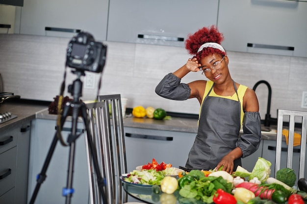 Foto gratuita mujer afroamericana filmando la transmisión de su blog sobre comida saludable en la cocina de casa