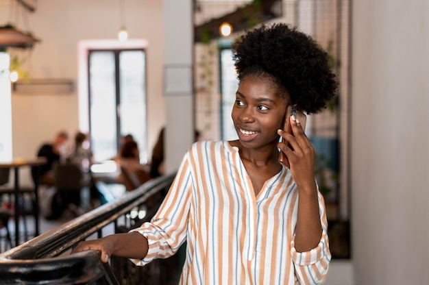 Mujer afroamericana hablando con alguien en su teléfono inteligente