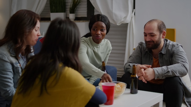 Mujer afroamericana hablando con amigos disfrutando del tiempo que pasan juntos