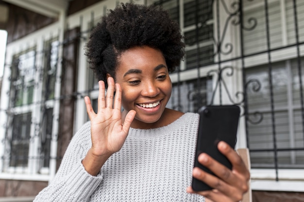 Foto gratuita mujer afroamericana haciendo una videollamada