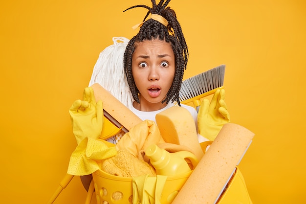 Mujer afroamericana nerviosa perpleja con rastas mira sorprendida