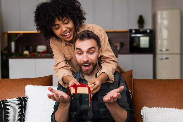 Mujer afroamericana ofreciendo un regalo a su novio