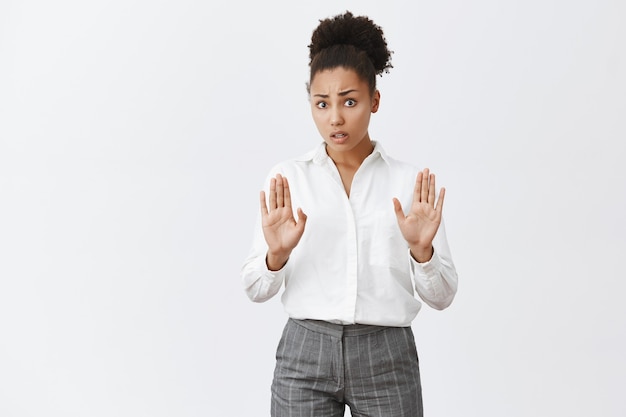 Mujer afroamericana preocupada diciendo que se detenga, levantando las manos para resolver la discusión pacíficamente