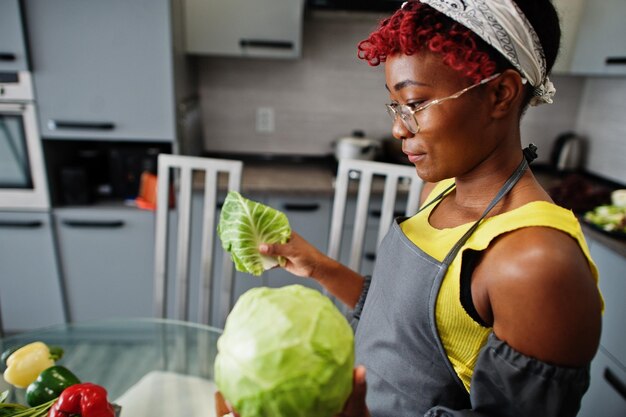 Mujer afroamericana preparando comida saludable en la cocina de casa Ella sostiene un repollo