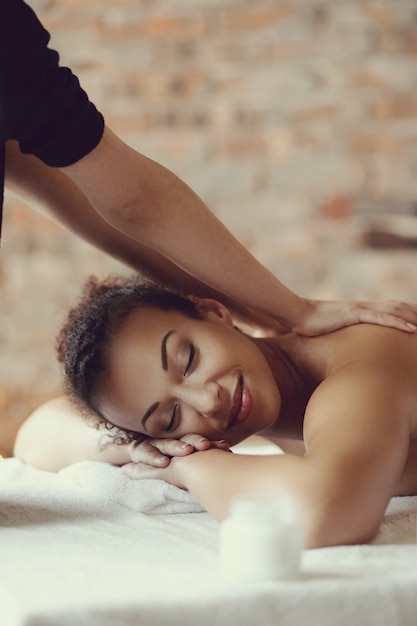 Foto gratuita mujer afroamericana que recibe un masaje relajante en el spa