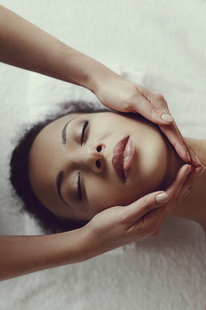 Mujer afroamericana que recibe un masaje relajante en el spa