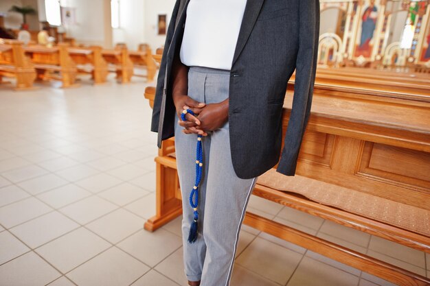 Mujer afroamericana rezando en la iglesia Los creyentes meditan en la catedral y el tiempo espiritual de oración Niña afro con rosario en las manos