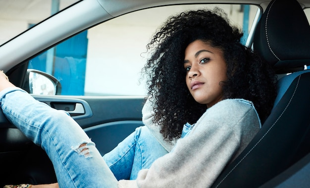 Foto gratuita mujer afroamericana sentada posando dentro de su coche mono vaquero