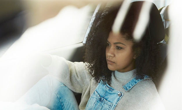 mujer afroamericana sentada posando dentro de su coche