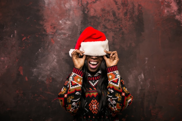 Mujer afroamericana con un sombrero rojo en Navidad