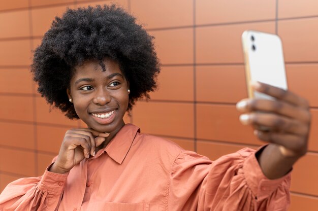 Foto gratuita mujer afroamericana tomando un selfie con su smartphone