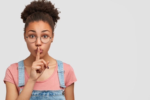 Mujer afroamericana vistiendo overoles de mezclilla