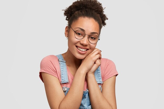 Mujer afroamericana vistiendo overoles de mezclilla