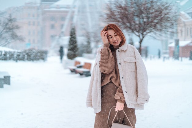 Mujer afuera en nevando día frío de invierno