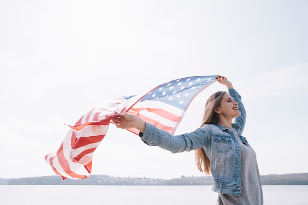 Mujer agitando gran bandera de Estados Unidos