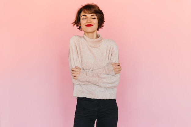 Foto gratuita mujer agradable en suéter posando con los ojos cerrados