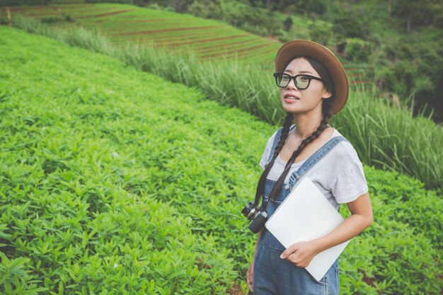 Mujer agrícola que inspecciona la planta con tabletas cultivadas: un concepto moderno