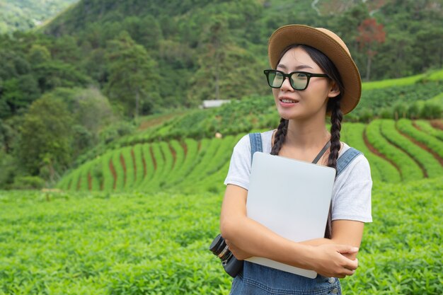 Mujer agrícola que inspecciona la planta con tabletas cultivadas: un concepto moderno